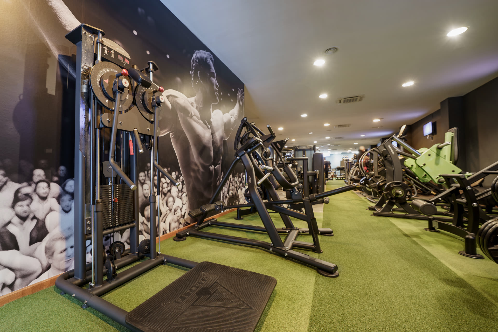 Sala principal con mural y máquinas de fuerza AL GYM CLUB